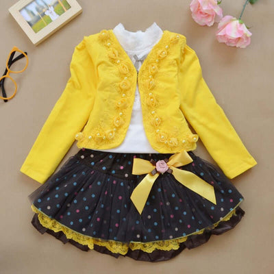 0-9Y Ruffle Tracksuit -Children's outfit with yellow jacket and black polka dot skirt on a beige background