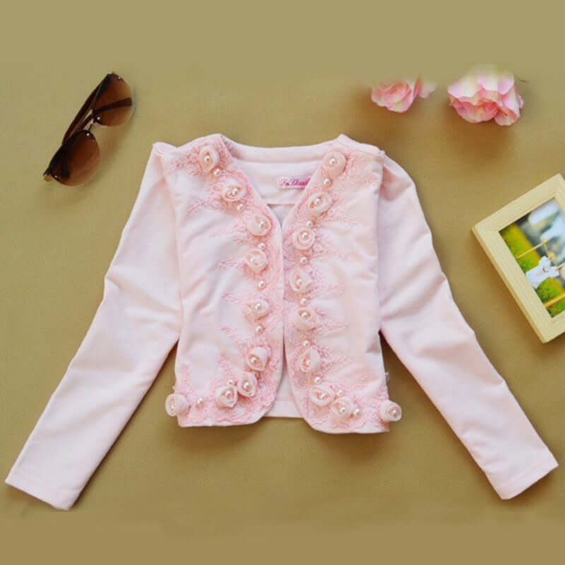 0-9Y Ruffle Tracksuit -Pink children's jacket with floral embellishments on a beige surface.