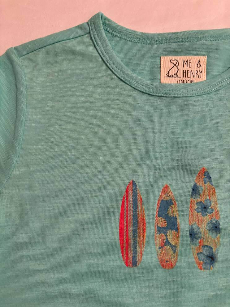 aqua-surfboard-printed-tee-Green t-shirt with surfboard designs and 'Me & Henry London' label on a pink background