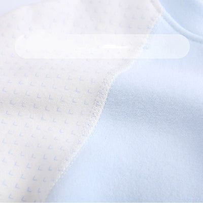 Baby Cotton Romper - Close-up of a textured fabric with a subtle pattern on a light blue background