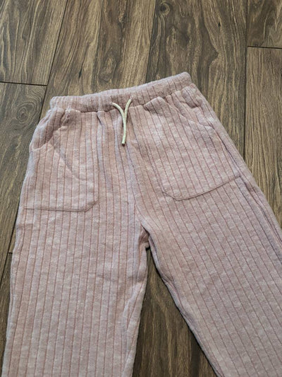Pink jogger pants on a wooden floor