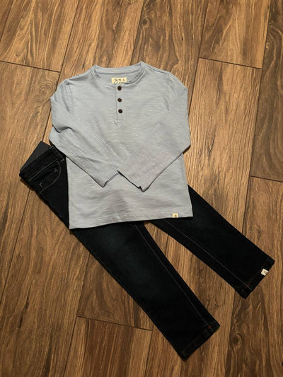 Gray long-sleeve shirt and black pants on a wooden floor