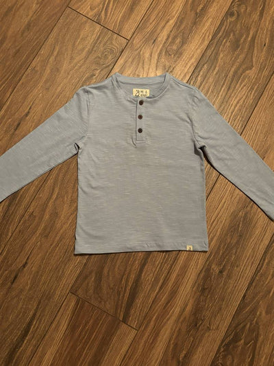 Gray long-sleeve shirt on a wooden floor