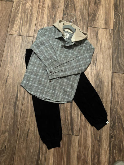 Plaid jacket and black pants on a wooden floor