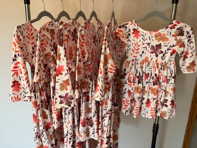 Falling Leaves 3/4 Sleeve Pocket Twirl Dress-Floral patterned dresses hanging on a rack against a neutral background