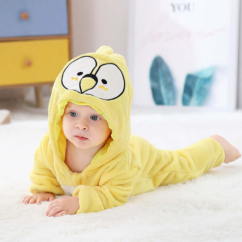 Flannel bodysuit-Baby wearing a yellow cartoon character onesie on a white blanket.