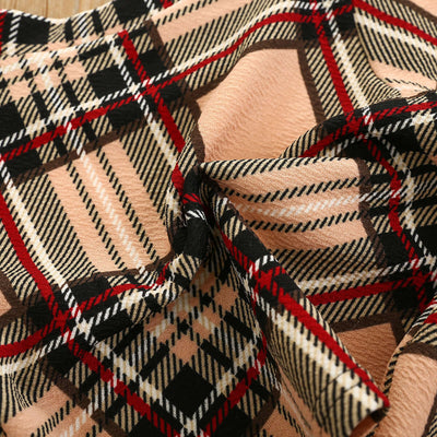 Girls Fashion Plaid-Close-up of plaid fabric with black, red, and beige colors.