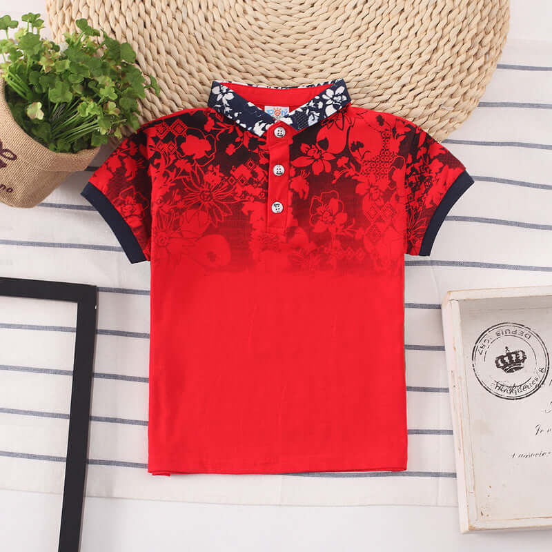 Kids Shirt Boys Tops-Red floral-patterned polo shirt on a striped surface with a woven basket and plant in the background.
