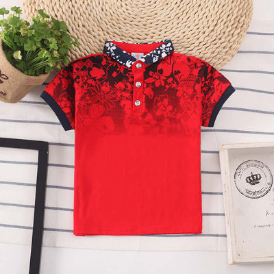 Kids Shirt Boys Tops-Red floral-patterned polo shirt on a striped surface with a woven basket and plant in the background.
