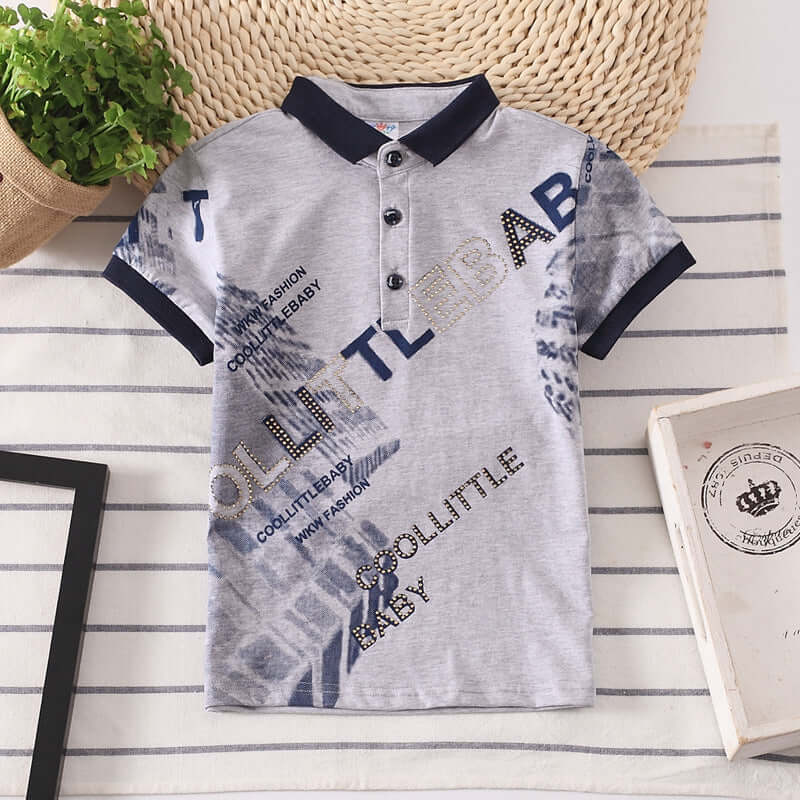 Kids Shirt Boys Tops-Gray children's polo shirt with blue text and patterns on a striped surface.