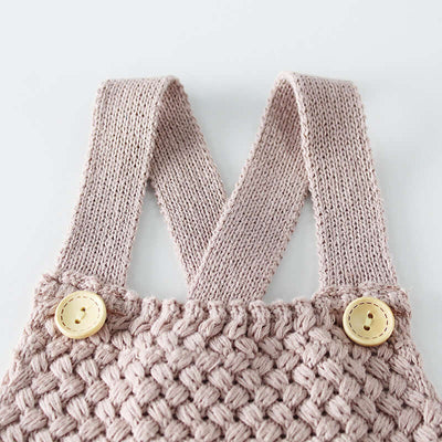 Knitted woolen bodysuit-Knitted pink baby romper with button details on a light gray background