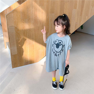 Loose Casual Short Sleeve Top-Child wearing a gray t-shirt with a logo, standing indoors near a wooden wall.