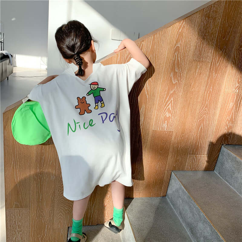 Loose Casual Short Sleeve Top-Child wearing a white t-shirt with cartoon characters and text, standing on a staircase.