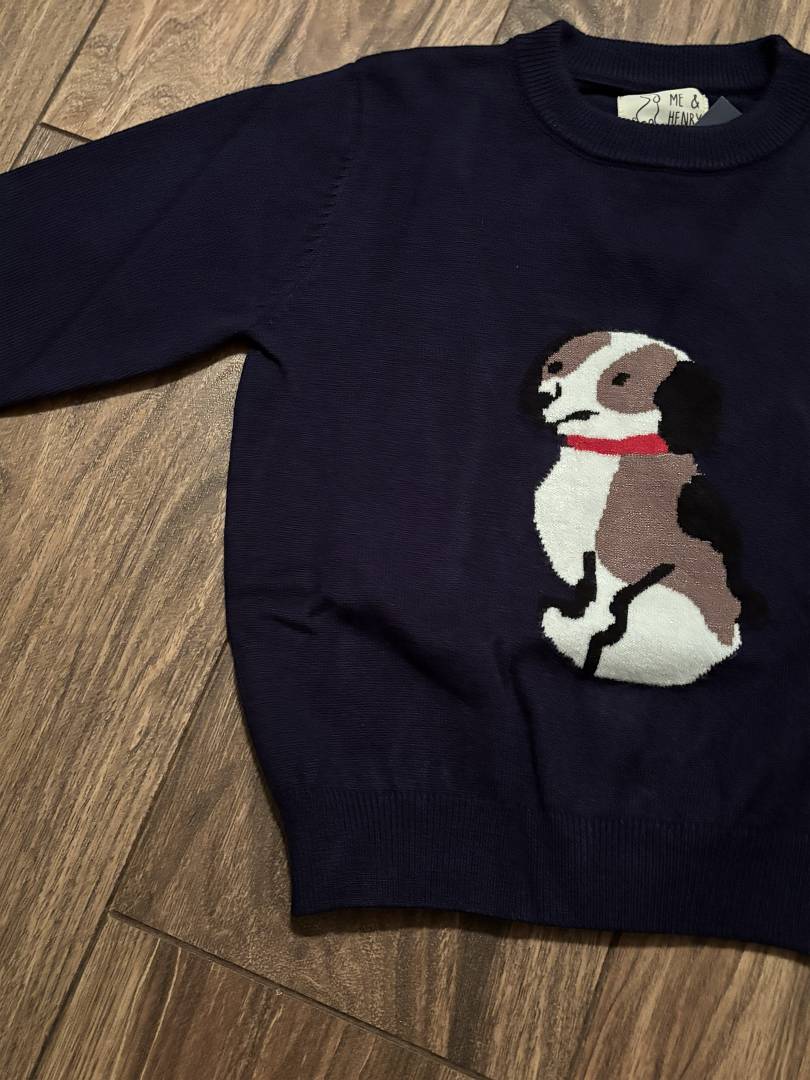 Navy blue sweater with a dog design on a wooden floor