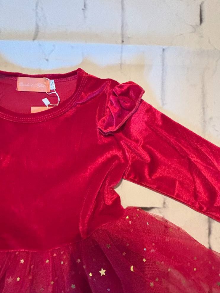 Red velvet outfit with star details on a neutral background