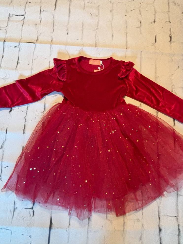 Red dress with a tutu skirt against a textured wall background