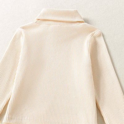 Solid Color Top  Plaid Skirt-Close-up of a beige ribbed sweater on a light background