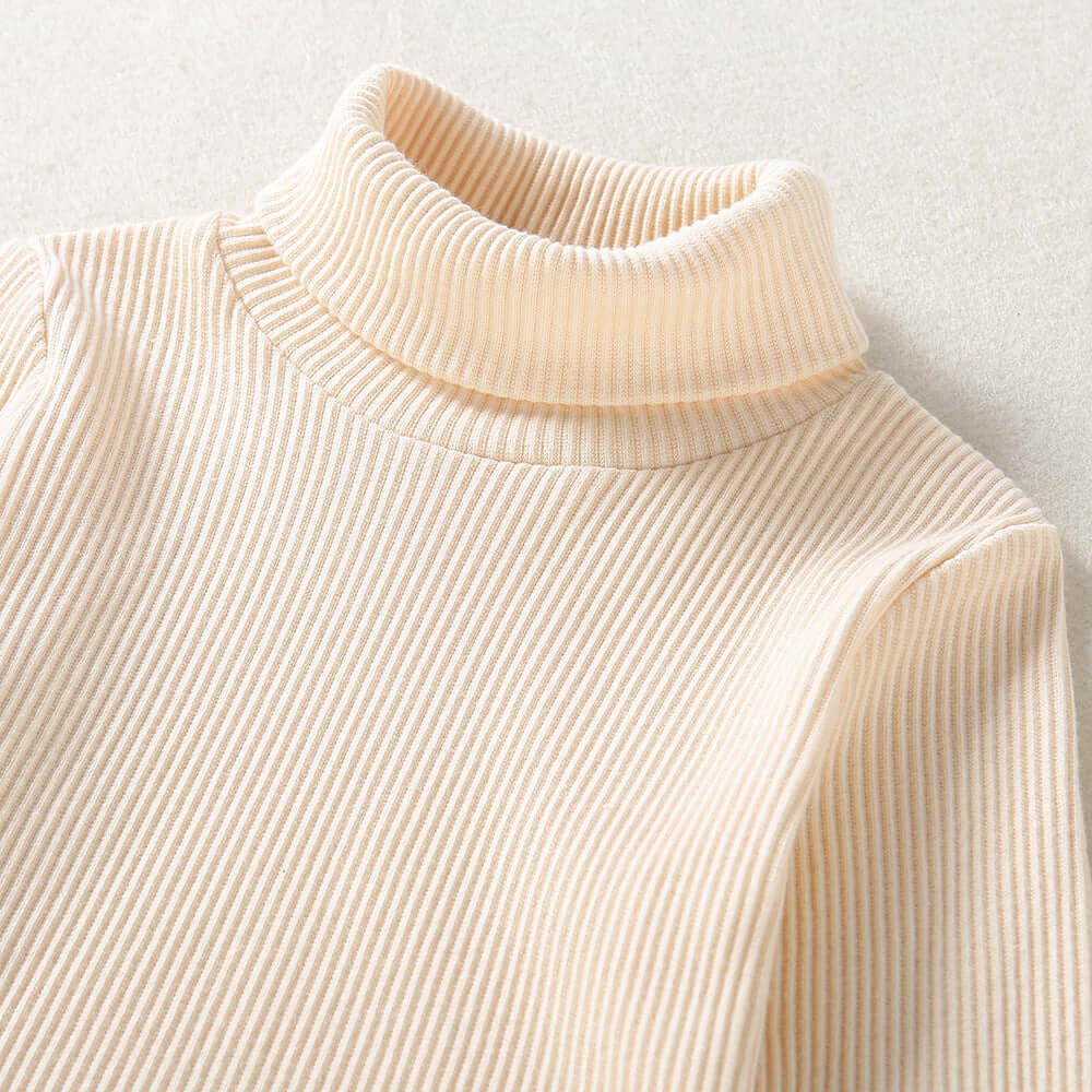 Solid Color Top  Plaid Skirt-Close-up of a beige ribbed turtleneck sweater on a light background