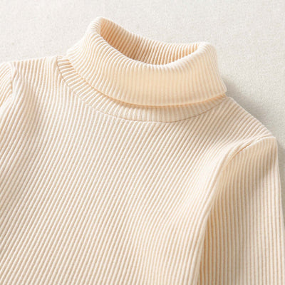 Solid Color Top  Plaid Skirt-Close-up of a beige ribbed turtleneck sweater on a light background