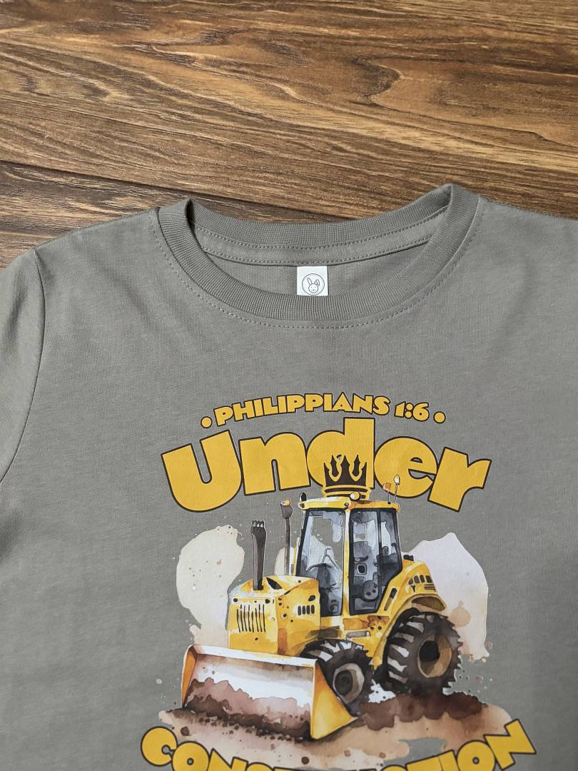 Under Construction Graphic Tee-Gray t-shirt with a yellow bulldozer graphic and text on a wooden surface
