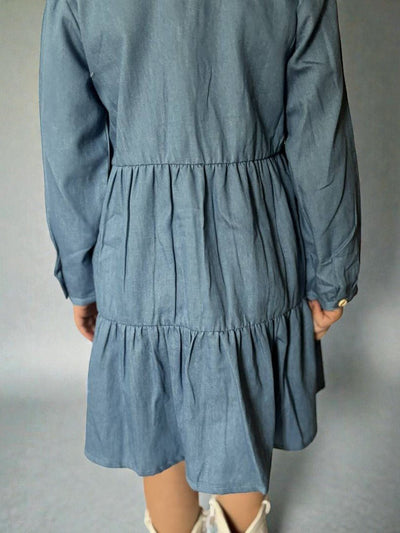 Blue dress worn by a person on a plain background