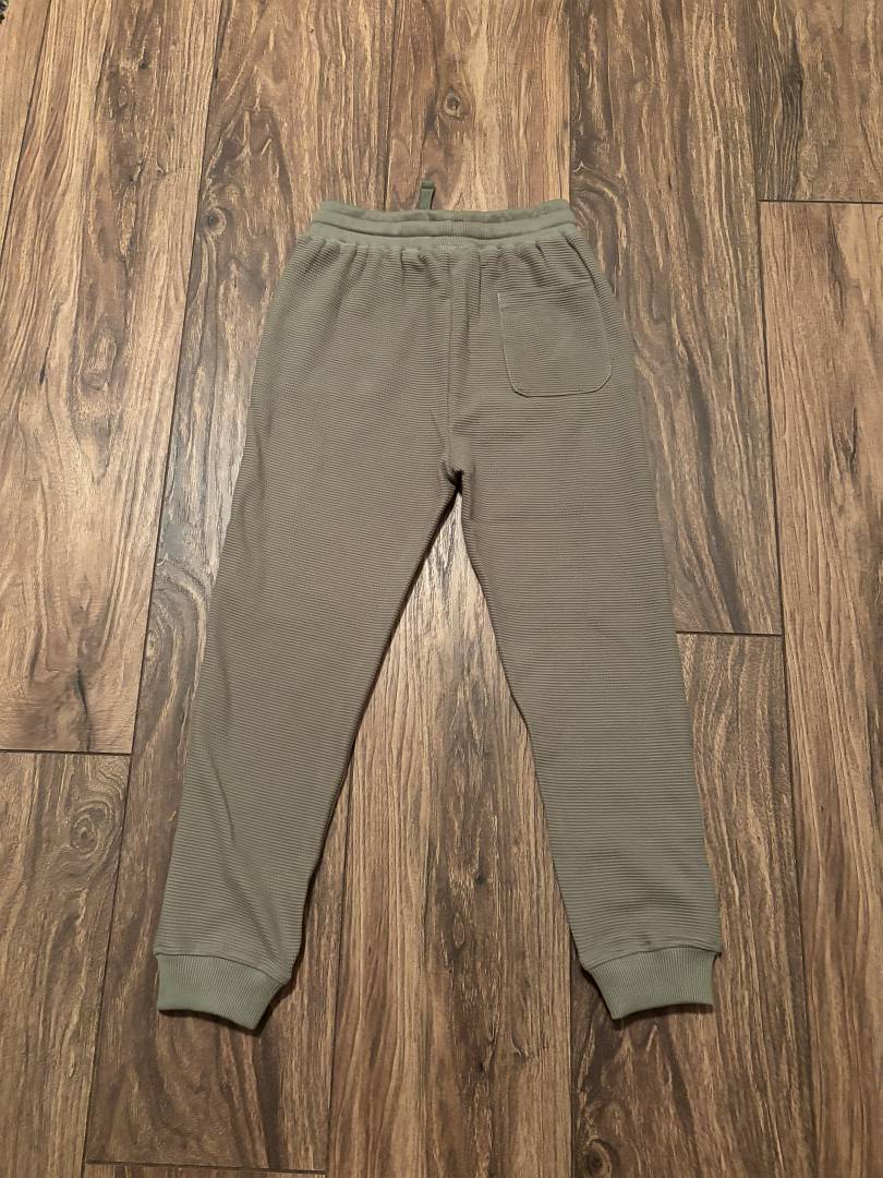 WES Waffle Jogger Pant-Olive Green sweatpants on a wooden floor